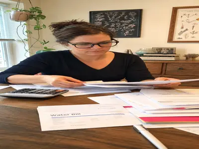 Person organizing bills at a table